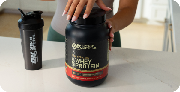 Optimum Nutrition whey protein container and shaker on a table