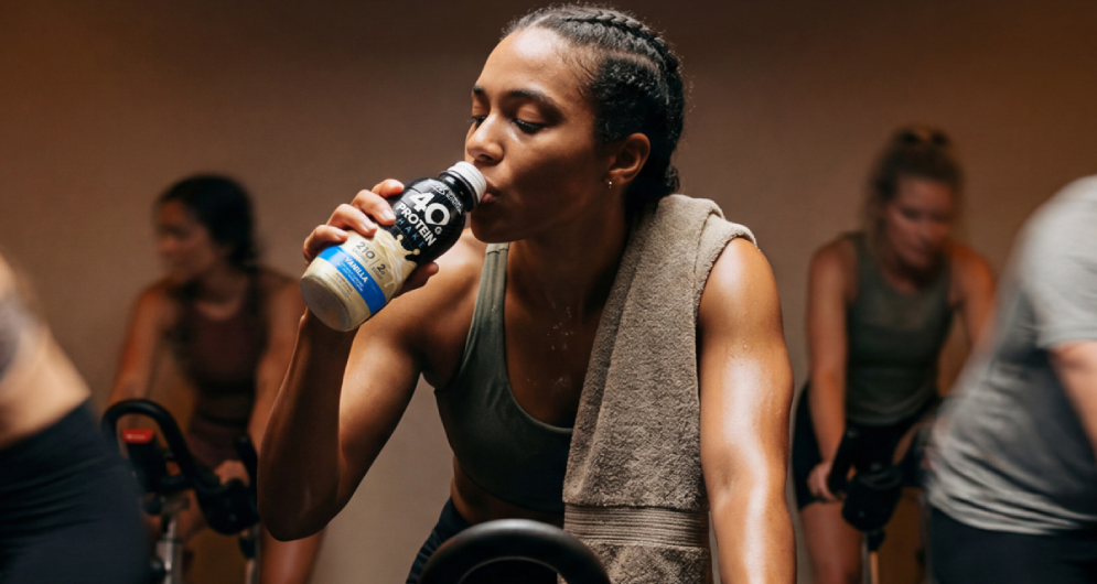woman drinking optimum nutrition protein drink in spin class