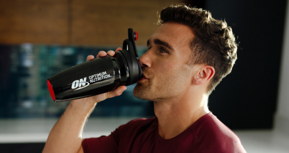 man drinking out of optimum nutrition shaker cup