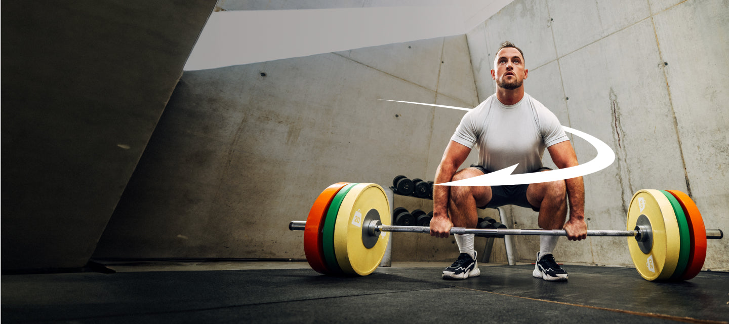 Man performing a barbell squat in a gym setting