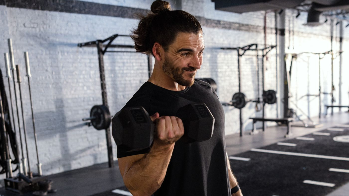 Man exercising with dumbbells in a gym